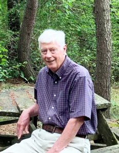 A photo of David seated at a picnic table